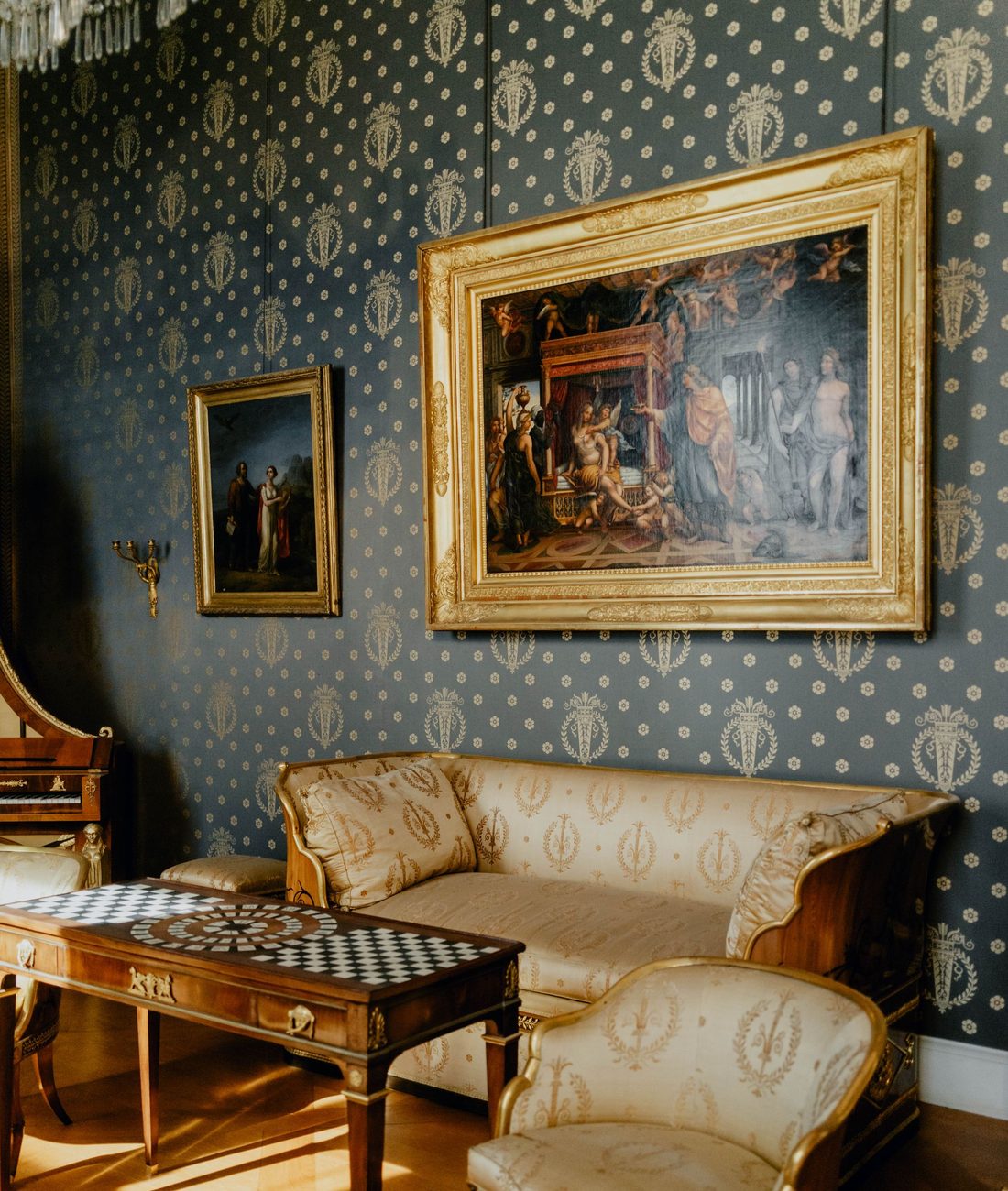 Blue-and-gold medallion damask wallpaper in an elegant drawing room with gilt furniture